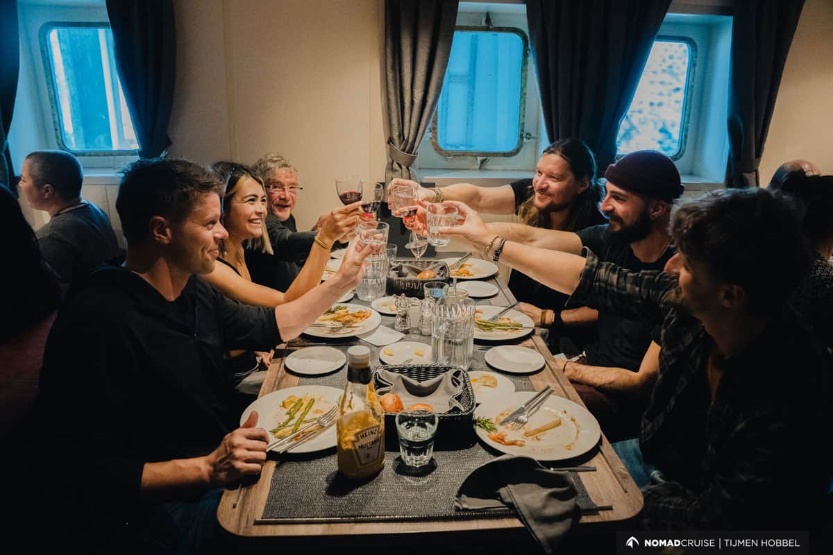 a group of six people cheersing while having dinner on board a cruise ship